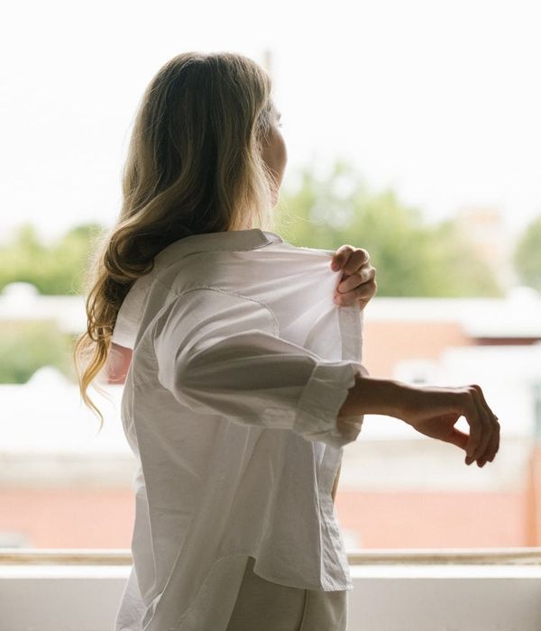 Woman performing a gentle cardio movement in a bright, airy room.